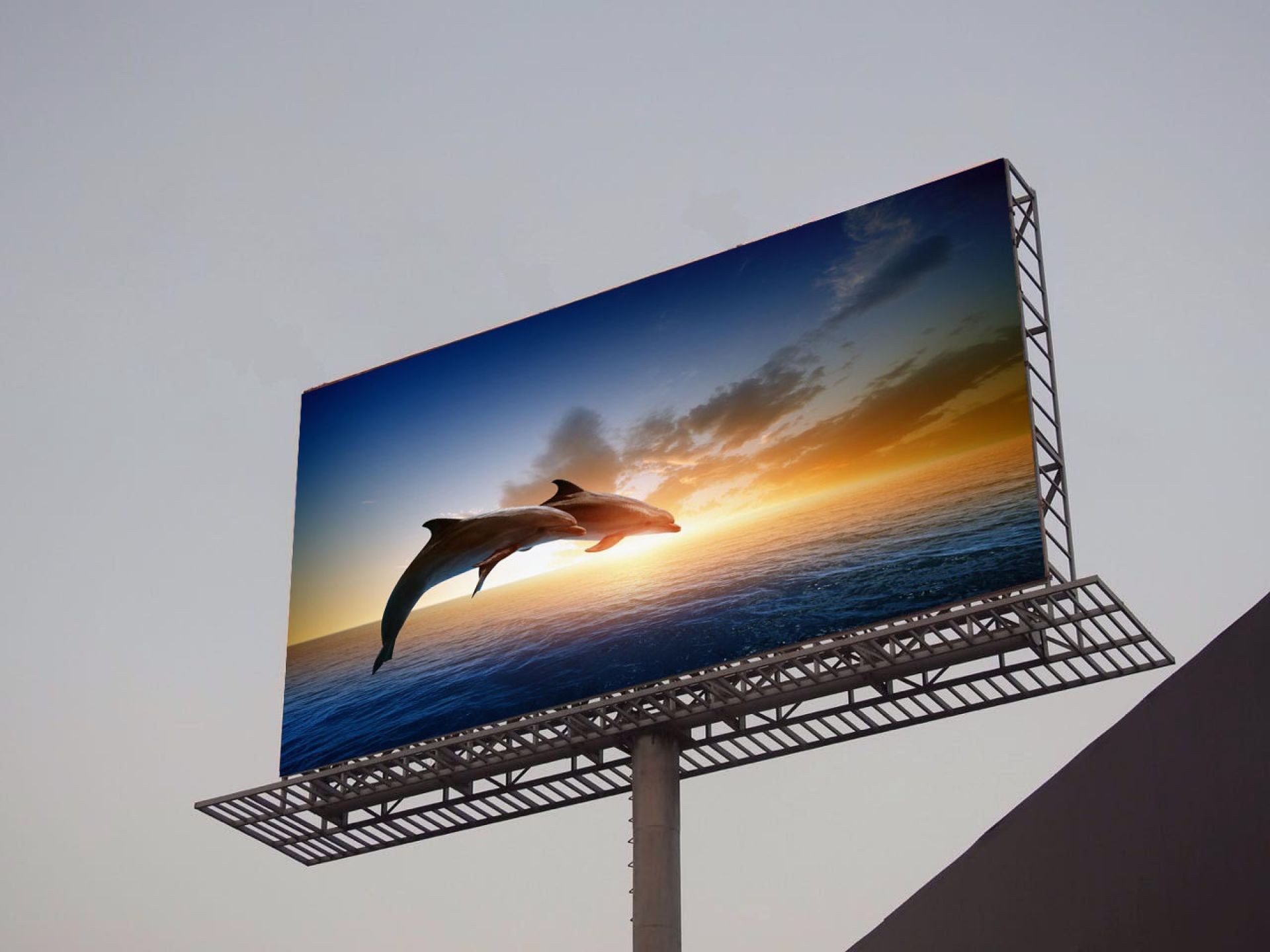 Billboard displaying dolphins jumping against an ocean sunset backdrop.